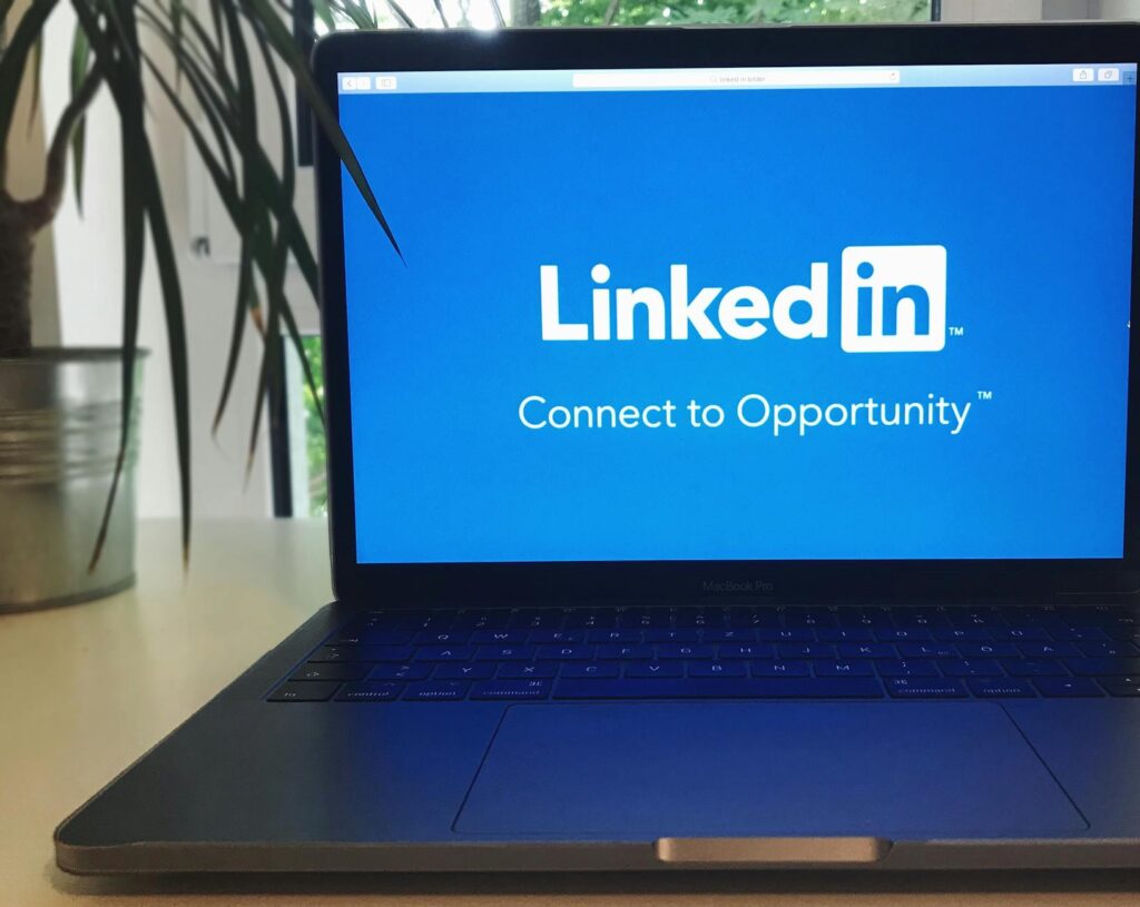 A laptop screen displaying the LinkedIn logo with the text 'Connect to Opportunity'.